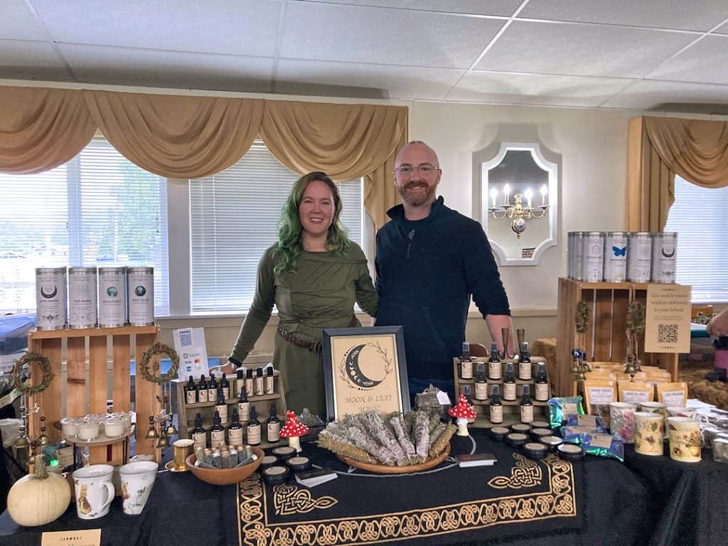 Davy & Tracy set up at a vendor event with a table full of product.